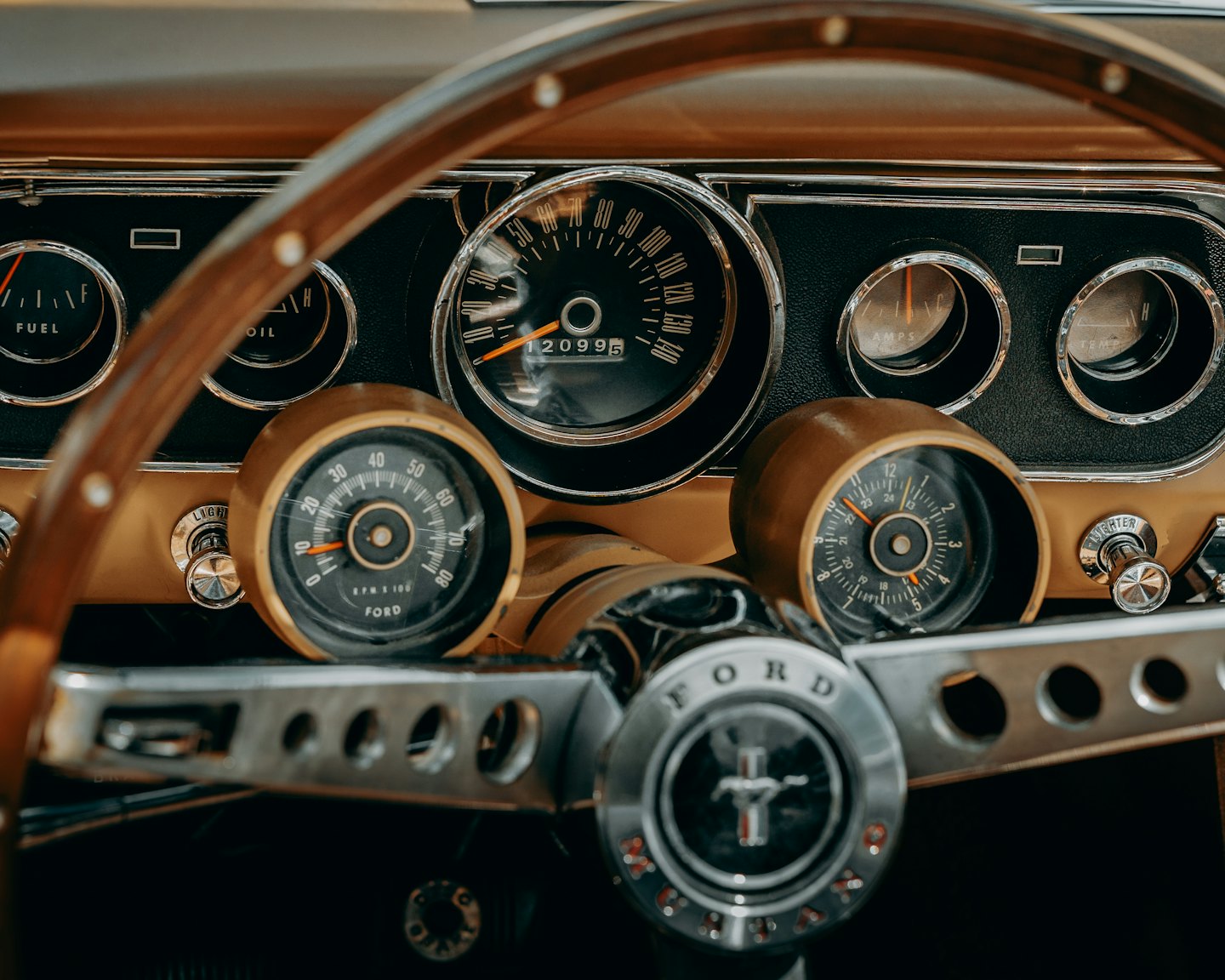 Armaturenbrett eines Oldtimers mit analogen Instrumenten und Holzlenkrad.