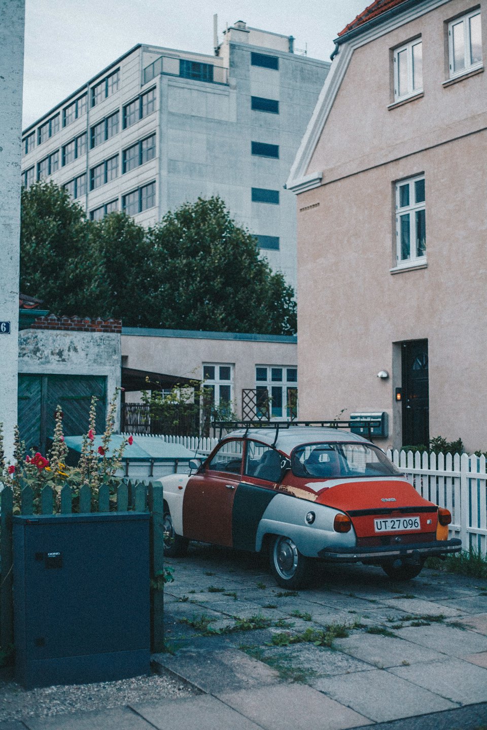 Ein mehrfarbiger Oldtimer-Saab auf einer Auffahrt.