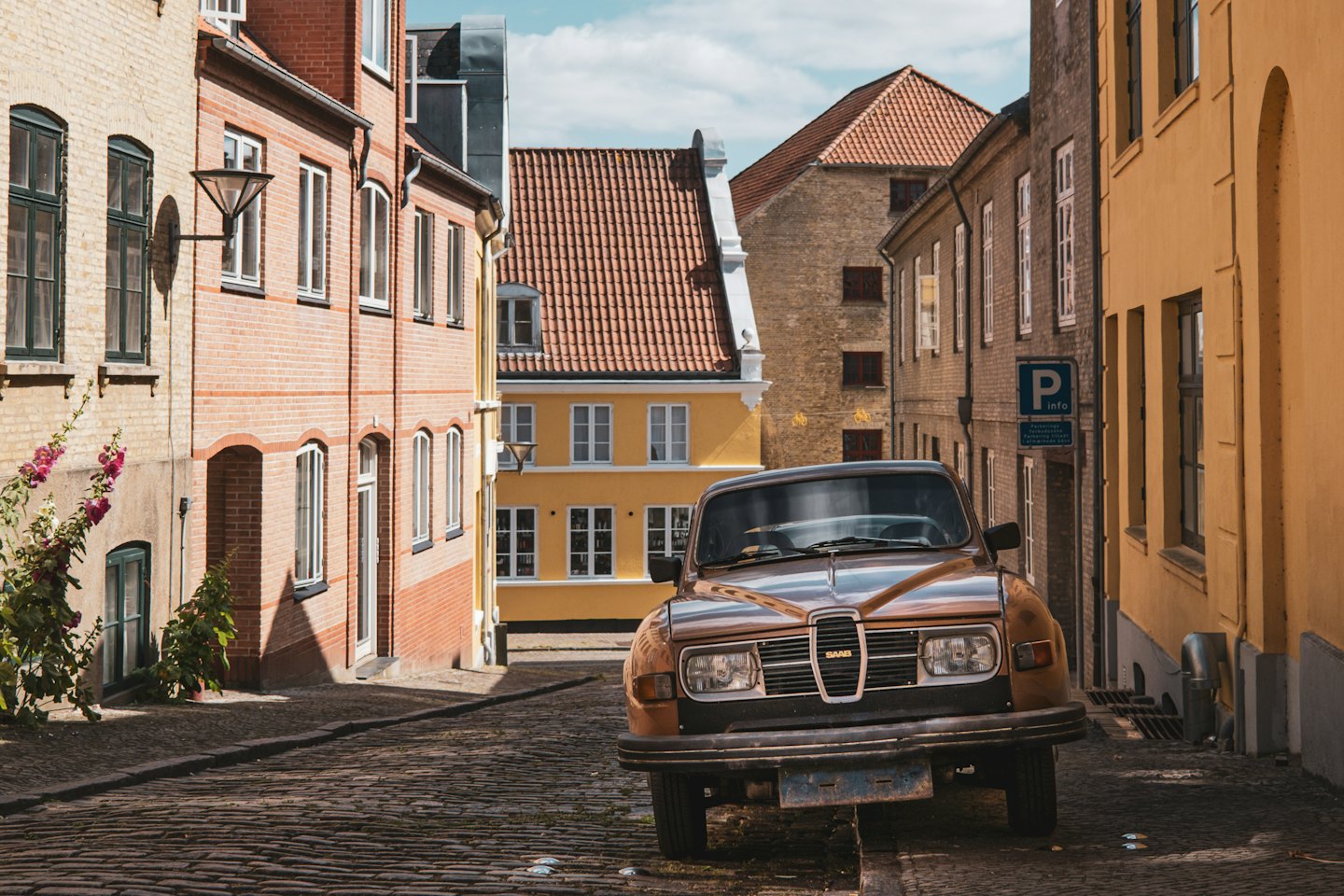 Ein alter brauner Saab, der auf einer schrägen Kopfsteinpflasterstraße geparkt ist.